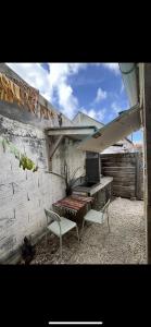 a patio with a bench and a table and a chair at Les Chambres d'Umoja in Grand-Bourg +6 photos