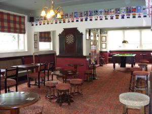 a restaurant with tables and chairs and a clock in a room at Edinburgh Arms in York