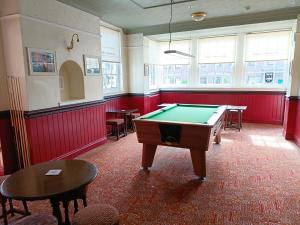 a pool table in a room with red walls and windows at Edinburgh Arms in York