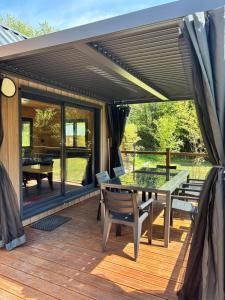 a patio with a table and benches on a deck at Tiny house chalet montagnard in Arcizans-Dessus