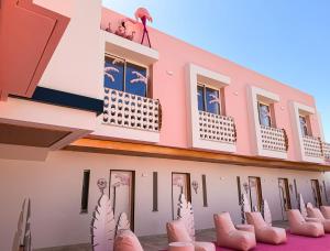 a building with a lot of chairs in front of it at On Pink Motel in Matalascañas