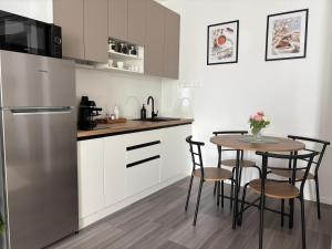 a kitchen with a table and a stainless steel refrigerator at PlatanHome 12 in Lenti