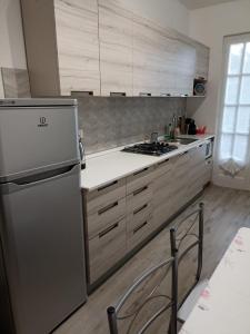 a kitchen with a stainless steel refrigerator and cabinets at Fior di Luna in Stresa +8 photos