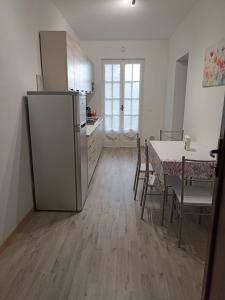 a kitchen and dining room with a table and a refrigerator at Fior di Luna in Stresa
