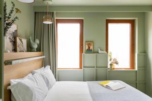 a bedroom with green walls and a bed with a book on it at Locke at Broken Wharf in London +16 photos