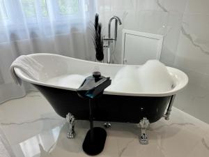 a black and white bath tub in a bathroom at LuxLife - Panorama Bergblick, Sauna, Balkon, Luxus Pur in Buchenberg