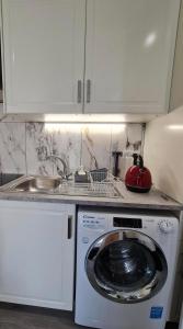 a kitchen with a washing machine and a sink at Cosy Condo near City & Airport in Dublin