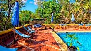 a swimming pool with chairs and umbrellas next to a pool at Suarez Hotel in Antsiranana