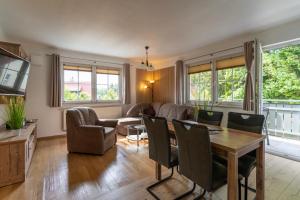 a living room with a table and chairs at Ferienanlage Zum Wildbach Schierke in Schierke +116 photos
