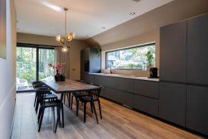 a kitchen with a table and chairs and a counter at Boshuis midden in het bos met houtkachel in Appelscha in Appelscha