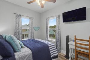 a bedroom with a bed and a tv and a window at 3BD Beach House by Next Step Property Management in Long Beach