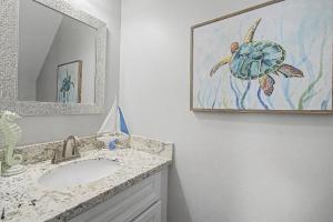 a bathroom with a sink and a picture of a turtle at 3BD Beach House by Next Step Property Management in Long Beach +26 photos