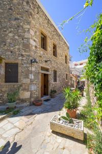 a stone building with a courtyard with potted plants at Old Town Tower House in Kos