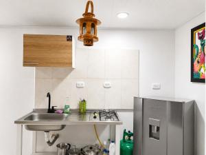 a small kitchen with a sink and a refrigerator at Central Apartment Salento Colombia in Salento