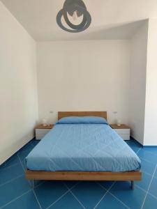a bedroom with a bed with a blue floor at L'Eco del Mare in Pisciotta