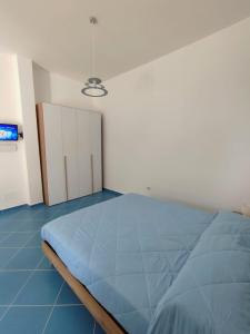 a bedroom with a large blue bed in a room at L'Eco del Mare in Pisciotta