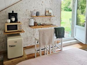 a kitchen with a microwave and a table with two chairs at La Kabane in Fierville-les-Mines +8 photos