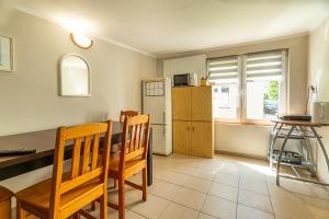 a kitchen with a table and chairs and a refrigerator at Willa Tina in Karwia