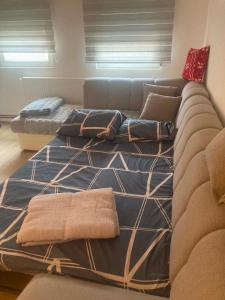two beds in a living room with a couch at Relax Apratman in Gornji Milanovac +9 photos