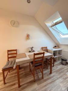 a dining room with a table and chairs and a skylight at Apartmán Bílé Karpaty in Strání