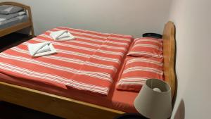 a bed with a red and white striped comforter at La Stermin in Viştea de Sus