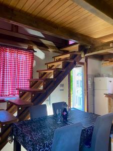 a dining room with a table with chairs and a staircase at Vikendica Stanković in Šipovo