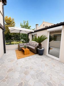 a patio with a couch and a table and an umbrella at Apartment Puntamica in Zadar