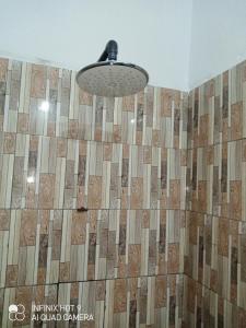a bathroom with a shower with a wooden wall at Hôtel Maximum in Agbézourhlan