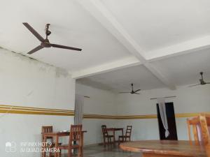 a living room with a ceiling fan and chairs at Hôtel Maximum in Agbézourhlan