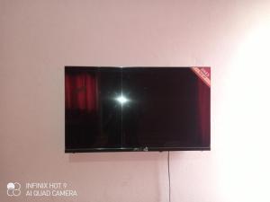a television hanging on a wall with a camera at Hôtel Maximum in Agbézourhlan