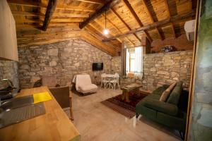 a living room with a stone wall at Dutlu Konak Taş Evleri in Soğucak