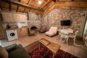 a living room with a stone wall at Dutlu Konak Taş Evleri in Soğucak