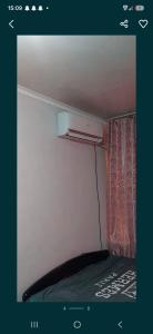 a room with a bed with a curtain and a window at 2-kichik daha in Andizhan