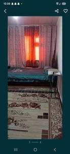 a bedroom with a bed with curtains and a window at 2-kichik daha in Andizhan