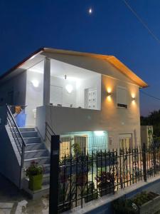 a small white house with stairs and a fence at Kurti Home in Agia Triada