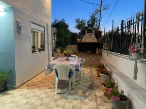 a patio with a table and chairs and a piano at Kurti Home in Agia Triada +2 photos