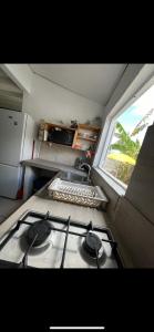a stove top in a kitchen with a window at Les Chambres d'Umoja in Grand-Bourg