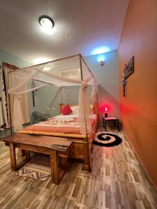 a bedroom with a canopy bed and a wooden floor at Kisoro Suits in Kisoro +22 photos