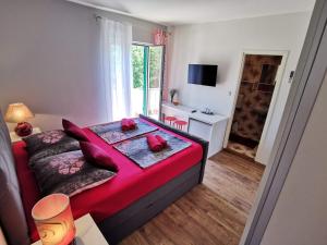 a bedroom with a bed with red pillows on it at Room`s Brica in Barbat na Rabu