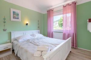 a bedroom with a white bed and a window at Home sweet home- Rab in Barbat na Rabu