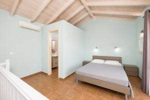 a bedroom with a bed in a white room at Villa Magda Dione in Gaios +9 photos