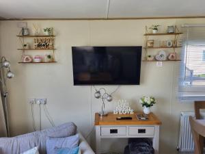 a living room with a tv on the wall at Cleethorpes beach haven site in Cleethorpes