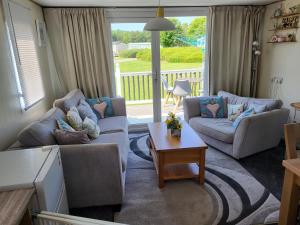 a living room with two couches and a table at Cleethorpes beach haven site in Cleethorpes