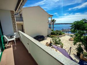 a balcony with a view of the water at Room`s Brica in Barbat na Rabu