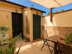 a patio with a wooden table and an umbrella at Casa Camelia Mare in Viareggio +3 photos
