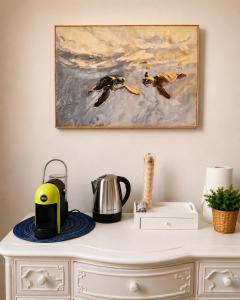 a painting of three birds in flight on a dresser at Casa Camelia Mare in Viareggio