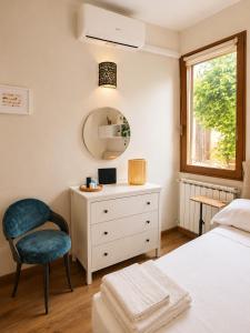 a bedroom with a bed and a chair and a dresser at Casa Camelia Mare in Viareggio