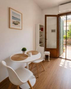 a dining room with a white table and chairs at Casa Camelia Mare in Viareggio