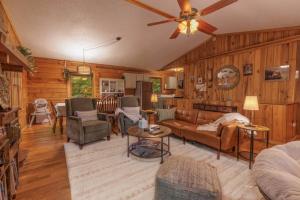 a living room with wooden walls and a ceiling fan at Re-Up Retreat King Bed, Hot Tub, Zero Pet Fees in Whittier