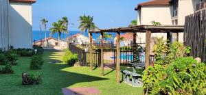 a garden with a swing and a playground at Topanga 17 in Uvongo Beach